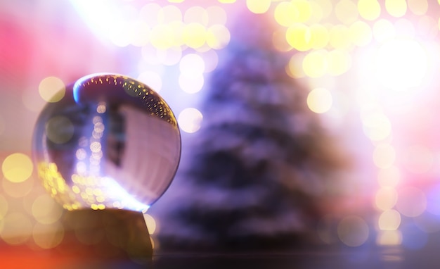 Sfera di cristallo sul pavimento con bokeh, luci dietro. Sfera di vetro con luce colorata bokeh, concetto di celebrazione.