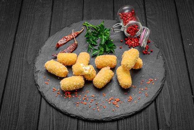 Sfera di formaggio fritto, pepite di formaggio su un piatto di legno