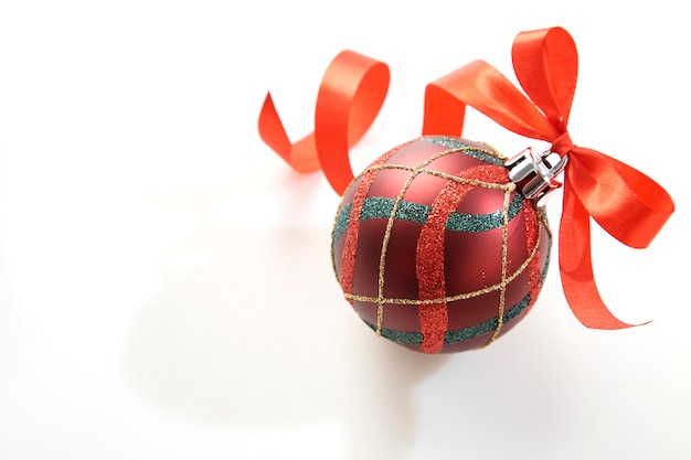 Sfera di Natale con fiocco rosso su bianco