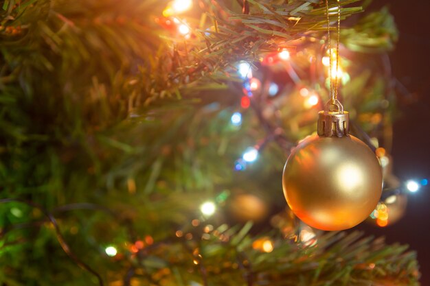 Sfere d'attaccatura dell'oro sulla ghirlanda e sugli ornamenti dell'albero di Natale dei rami del pino