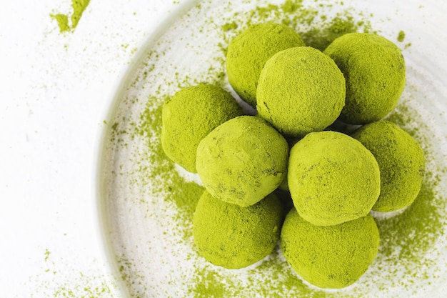 Sfere di energia Matcha in un piatto bianco su un bianco