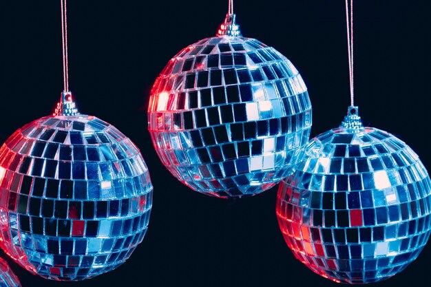 Sfere scintillanti della discoteca che pendono nell'aria contro il nero