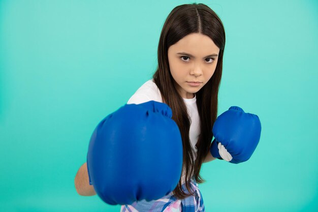 Sfida sportiva punzonatura concentrata pugile di successo per bambini lotta per il successo bambino fiducioso pronto per la competizione potenza ad eliminazione diretta e autorità ragazza in abbigliamento sportivo guantoni da boxe messa a fuoco selettiva