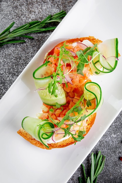 Sfiziosi stuzzichini Bruschetta con salmone affettato cetriolo fresco anelli di cipolla rossa e rucola Crostini tostati con frutti di mare e lattuga