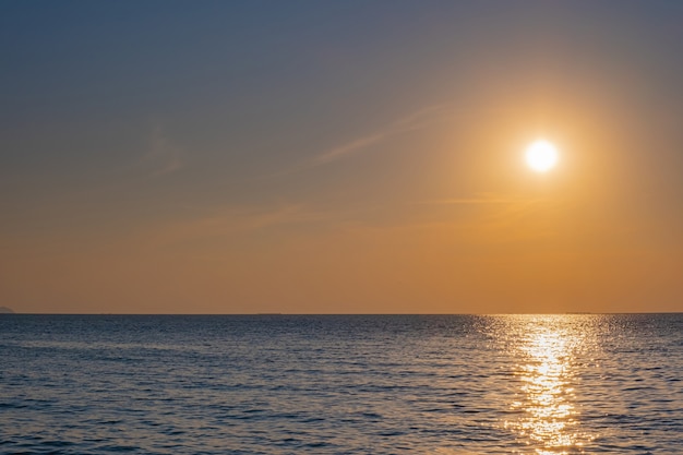 Sfocato del tramonto colorato tropicale sopra l'oceano sulla spiaggia.