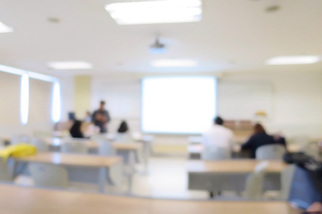 Sfocato di aula o sala riunioni con tavolo lungo, sedie, proiettore e grande finestra. Formazione scolastica.