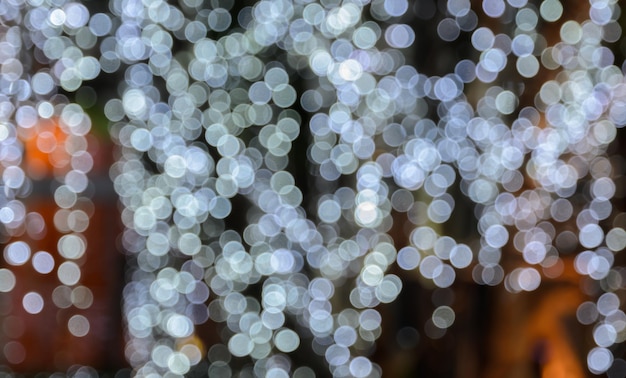Sfocatura dello sfondo bokeh delle luci di Natale appese all'albero