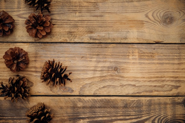 Sfondio con coni di pino su una tavola di legno scuro composizione di Natale e Capodanno con un posto per copiare il testoVisualizzazione dall'alto
