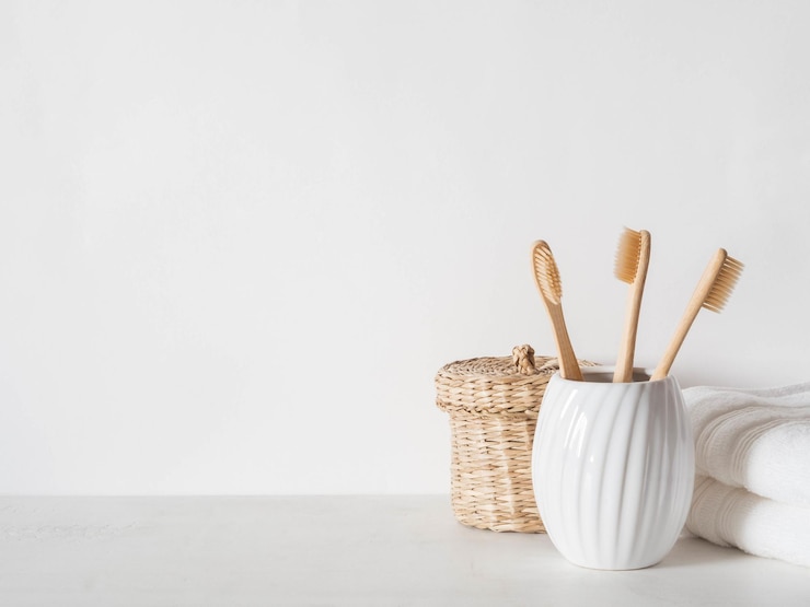 Foto sfondio del bagno con spazzolini da denti in bambù in scatola di viti di vetro ceramico e asciugamani bianchi