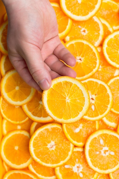 sfondo arancione. fetta d'arancia in mano