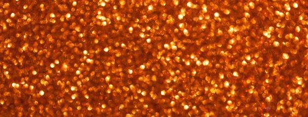 Sfondo arancione sfocato scintillante da piccole macro di paillettes Bokeh scintillante rosso brillante della ghirlanda di Natale