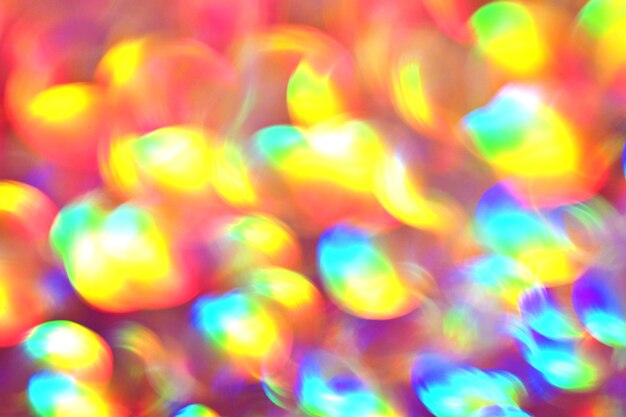 Sfondo arcobaleno, effetto sfocato. I cerchi luminosi natalizi incandescenti vengono creati dal bokeh nella fotocamera e nell'obiettivo. Sfondo per il design.