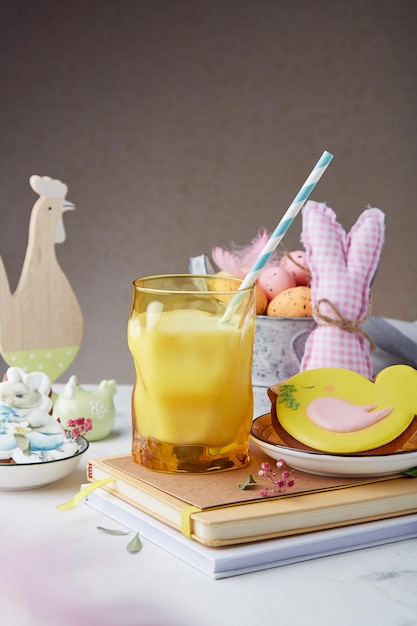 Sfondo artistico di Pasqua Bicchiere di latte e biscotti smaltati decorati con decorazioni da tavolo artigianali Cucina estetica accogliente primaverile