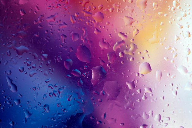 Sfondo astratto con gocce d'acqua su uno sfondo multicolore con tutti i colori dell'arcobaleno