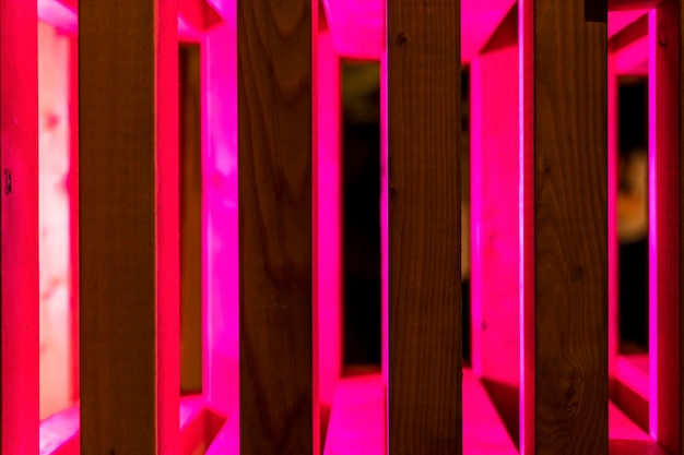 Sfondo astratto di doghe in legno illuminate con luce al neon rossa