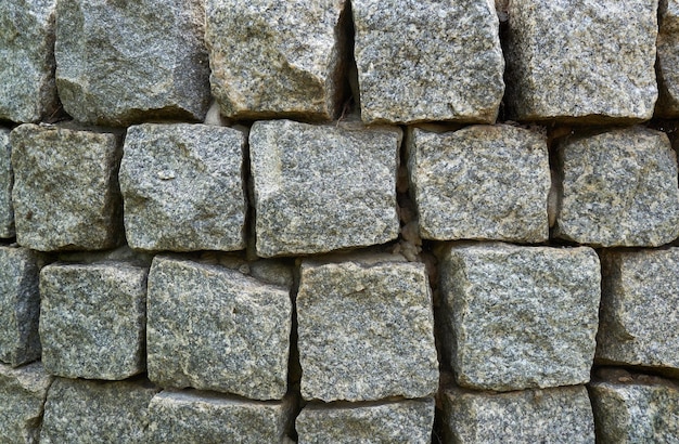 Sfondo astratto di parete rivestita di pietre di granito di forma quadrata