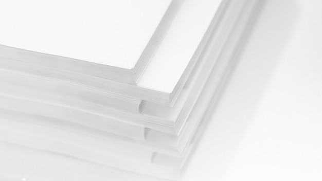 Sfondo astratto, minimalismo. Diverse pile di carta bianca per fotocopiatrice, su uno sfondo bianco. Concetto di lavoro d'ufficio.