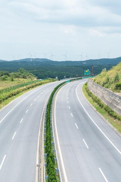 Sfondo autostrada curva con parco eolico