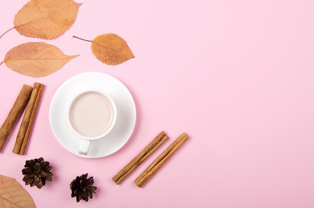 Sfondo autunnale con caffè, cannella e foglie su sfondo chiaro