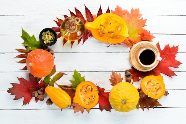 Sfondo autunnale con caffè zucca foglie autunnali distese su uno sfondo di legno bianco Vista dall'alto Spazio libero per il testo