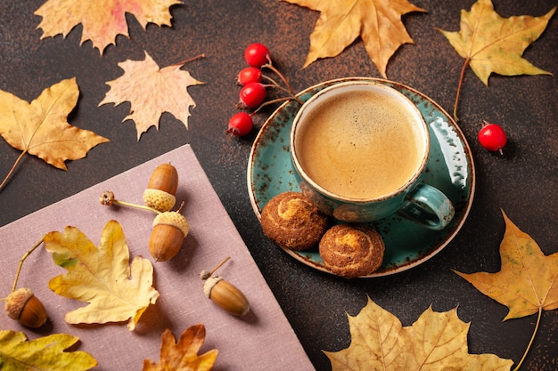 Sfondo autunnale con tazza di caffè nero e decorazioni autunnali