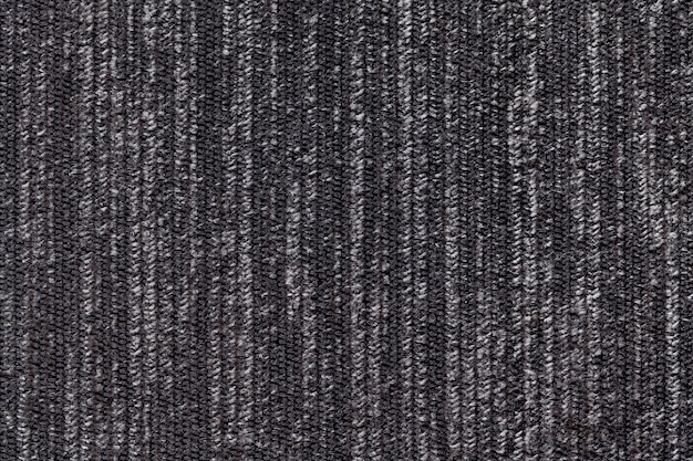 Sfondo bianco e nero di una materia tessile a maglia. Tessuto con un primo piano a strisce di struttura.