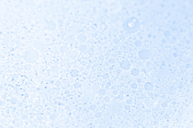 Sfondo blu frizzante con piccole bolle sulla superficie dell'acqua o dell'olio