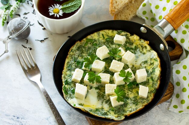 Sfondo colazione Uova fritte con feta di spinaci su tavola di pietra Spazio libero per il testo