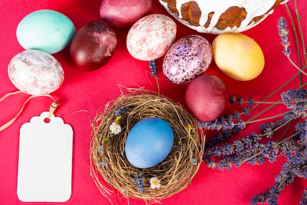 Sfondo colorato con uova di Pasqua su sfondo rosso. Felice Pasqua concetto. Può essere utilizzato come poster, sfondo, biglietto di auguri. Appartamento laico, vista dall'alto, copia dello spazio. Foto di studio