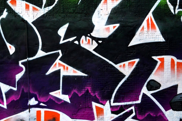 Sfondo colorato di graffiti che dipingono opere d'arte con strisce di aerosol luminose sulla parete metallica