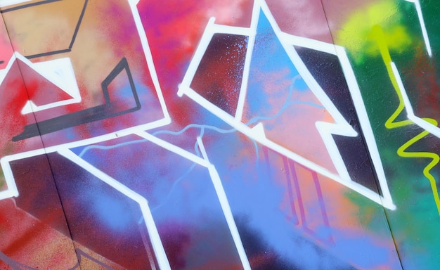 Sfondo colorato di graffiti che dipingono opere d'arte con strisce di aerosol luminose sulla parete metallica