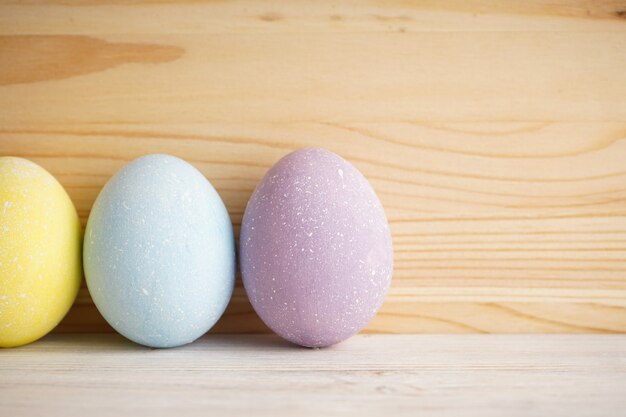 Sfondo colorato di uova di Pasqua su sfondo di legno