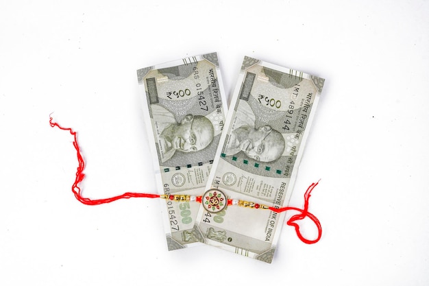 sfondo concettuale rakhi con rupia indiana, banda rakhi