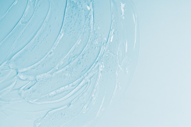 Sfondo cosmetico astratto da gel trasparente denso o antisettico, ialurone su sfondo blu