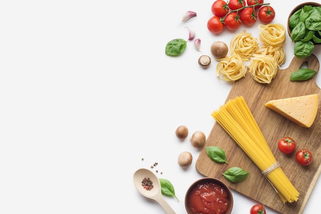 Sfondo culinario con ingredienti per cucinare la pasta con i pomodori su sfondo bianco