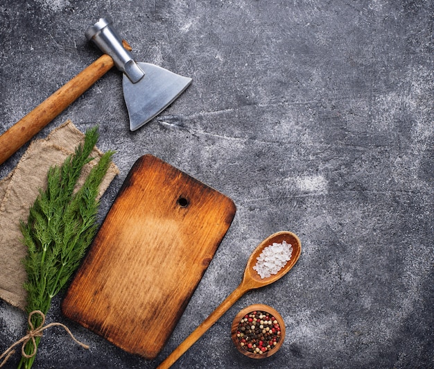 Sfondo culinario con spezie, tagliere e ascia