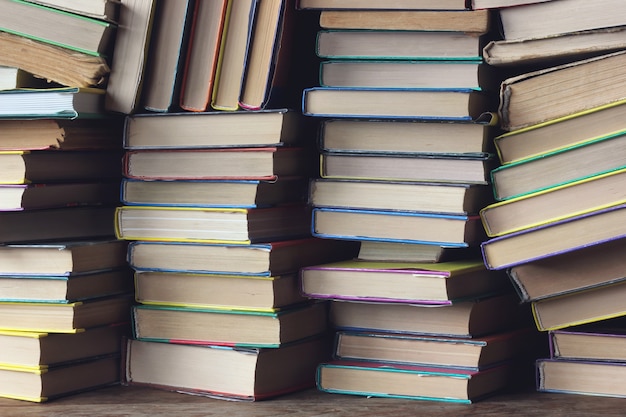 Sfondo da libri. Le pile di libri sul primo piano dello scaffale. Biblioteca. Di nuovo a scuola.