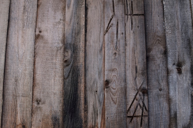 Sfondo da tavole di legno con un insolito motivo astratto. Segni antichi su tavole di legno.