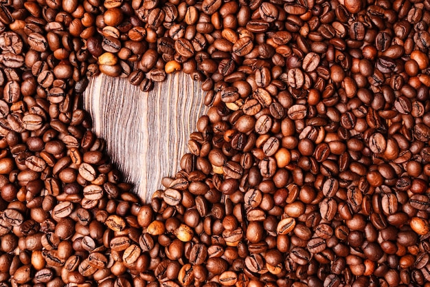 Sfondo dai chicchi di caffè e un cuore dal caffè la vista dall'alto