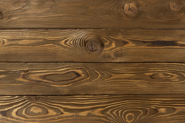 Sfondo decorativo in legno con posto per il testo. Tavole di larice marrone medio chiaro con nodi e buchi, trama astratta. Concetto di materiali naturali per la decorazione domestica.