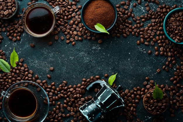 Sfondo del caffè Caffè in tazze e chicchi di caffè su uno sfondo di pietra nera Vista dall'alto Spazio libero per il testo