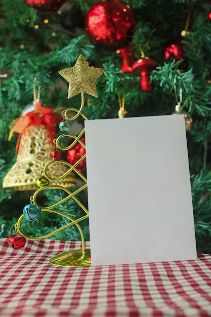 Sfondo del modello di Natale con biglietto di auguri bianco vuoto per lettera di invito o marketing e-mail in entrata. Circondato da decorazioni natalizie.