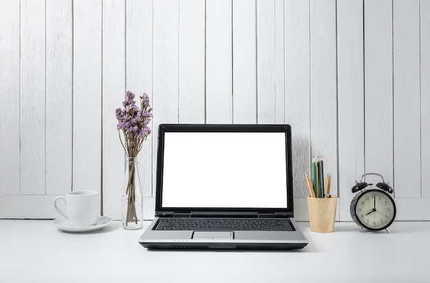 sfondo del posto di lavoro con computer portatile moderno schermo bianco vuoto. Blackgro bianco in legno