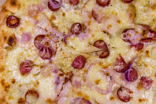 Sfondo della pizza con salsicce, prosciutto e parmigiano