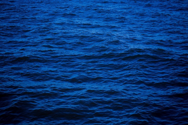 sfondo della superficie dell'acqua di mare blu scuro profondo Disegno dello sfondo per opere d'arte o aggiunta di messaggi di testo