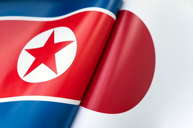 Sfondo delle bandiere della Corea del Nord e del Giappone Il concetto di interazione o contrasto tra i due paesi Relazioni internazionali Negoziati politici Competizione sportiva