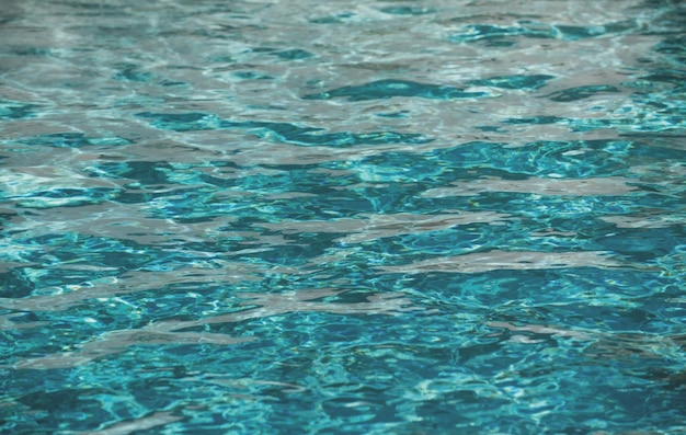 Sfondo di acqua blu in piscina con riflesso del sole ondulazione onda d'acqua in piscina Sfondo di acqua limpida