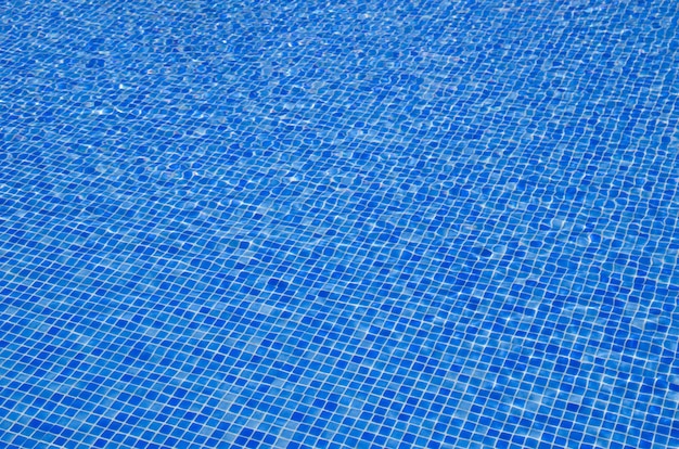 sfondo di acqua della piscina blu con riflessi del sole