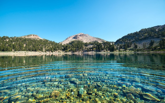 Sfondo di acqua limpida del lago sotto le montagne