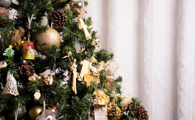 Sfondo di albero di natale chic per il ritratto cartolina di natale con palline d'oro e sfondo paesaggio tenda bianca